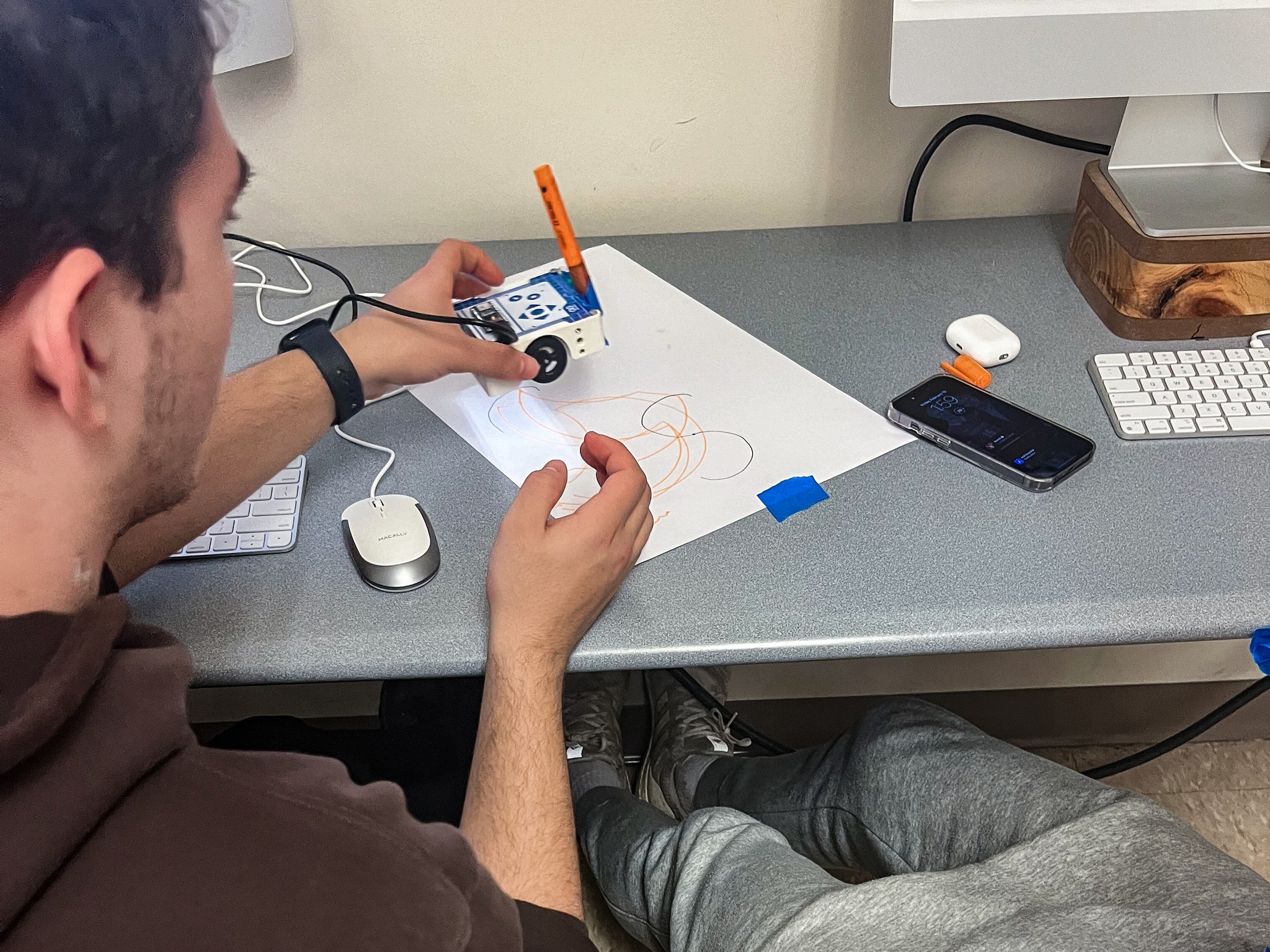Close-up of a student using the Arduino Alvik robot car to create drawings during usability testing session