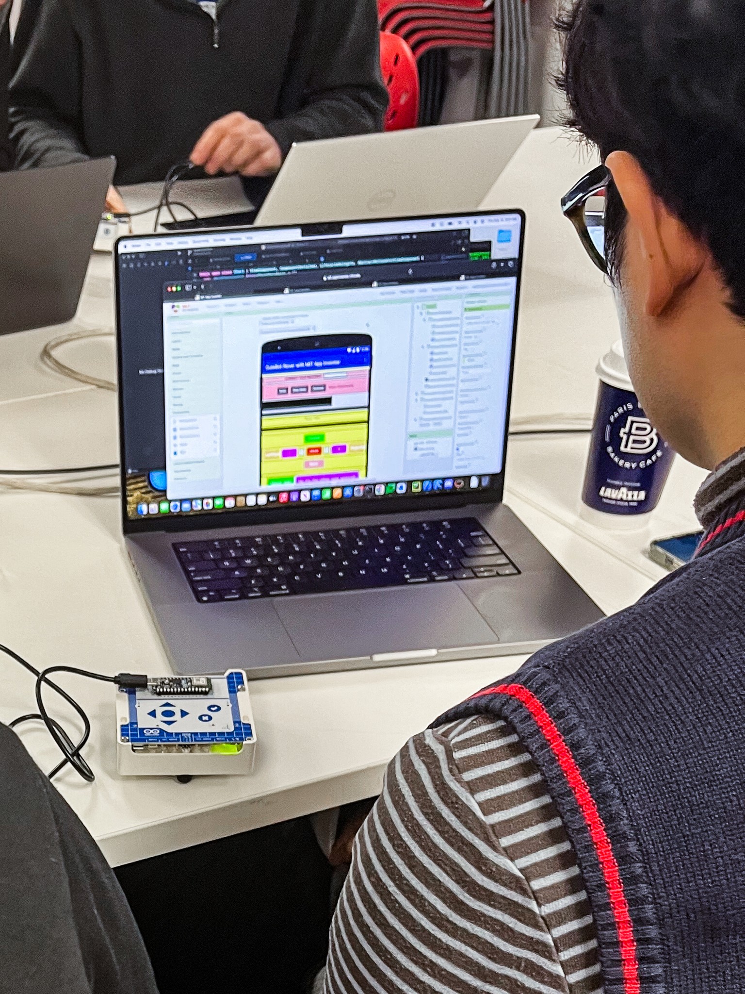 Close-up of a TUFTS University student using the Arduino Alvik robot car by hooking it up to a custom app during usability testing session