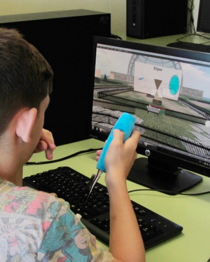 a kid using the FlyStick tangible user interface to interact physically with digital shapes