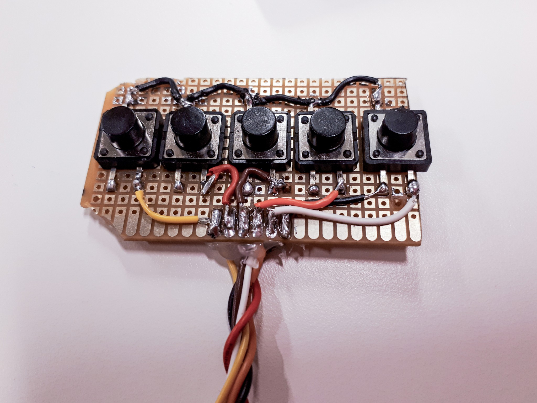 five buttons soldered to an electronic board